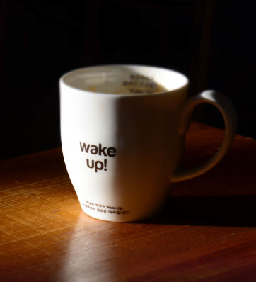 כוס קפה על שולחן עם כיתוב wake up